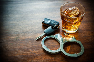 handcuffs, a glass of whisky, and car keys